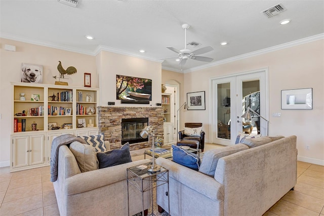 tiled living room with crown molding, a fireplace, and french doors