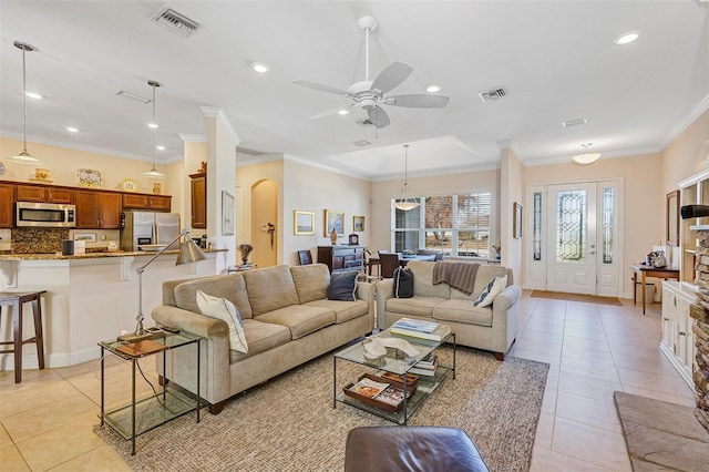 tiled living room featuring ornamental molding and ceiling fan