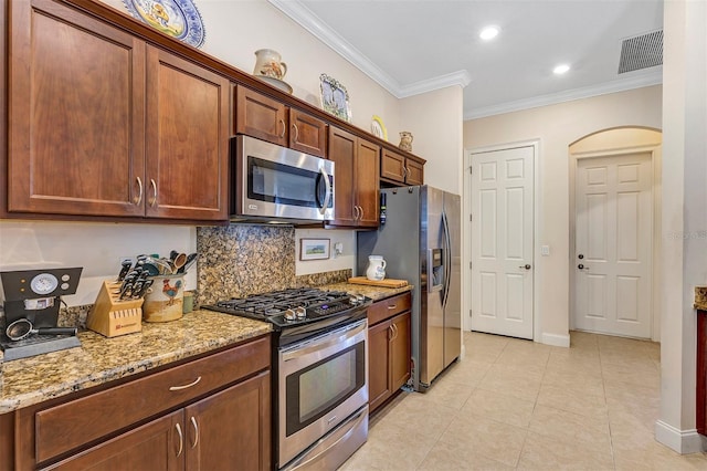 kitchen featuring light stone counters, appliances with stainless steel finishes, and crown molding