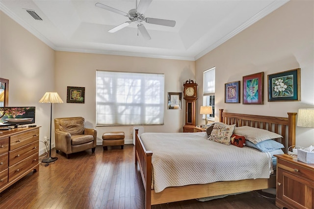 bedroom featuring dark hardwood / wood-style flooring, a tray ceiling, ornamental molding, and ceiling fan