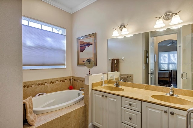 bathroom featuring tiled tub, crown molding, a healthy amount of sunlight, and vanity