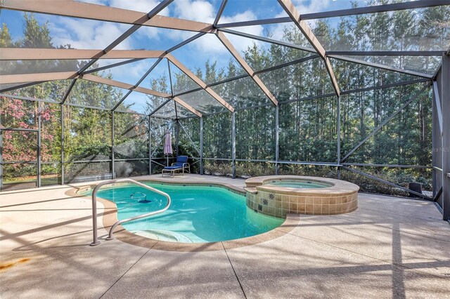 view of pool with an in ground hot tub, a patio, and glass enclosure