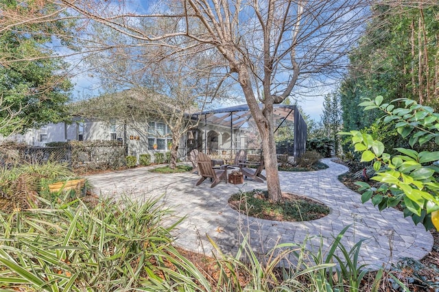 view of patio featuring a fire pit and a lanai