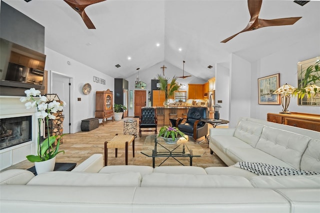 living room with high vaulted ceiling, light wood-type flooring, and ceiling fan