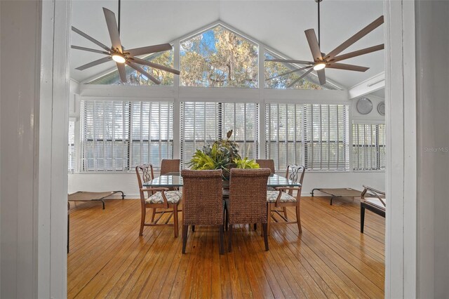dining space featuring ceiling fan, vaulted ceiling, and light hardwood / wood-style flooring