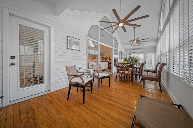 sunroom with vaulted ceiling with beams, an AC wall unit, and ceiling fan