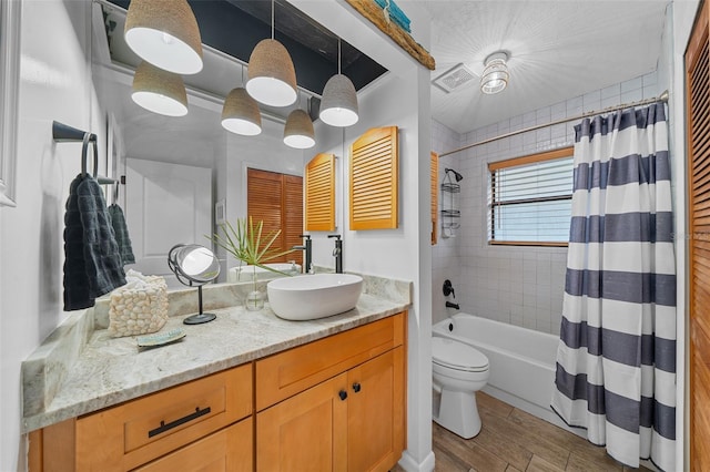 full bathroom featuring hardwood / wood-style flooring, vanity, toilet, and shower / bath combination with curtain
