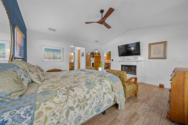 bedroom featuring vaulted ceiling, a premium fireplace, and ceiling fan