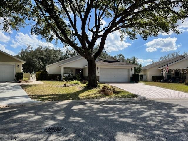 single story home featuring a garage and a front lawn