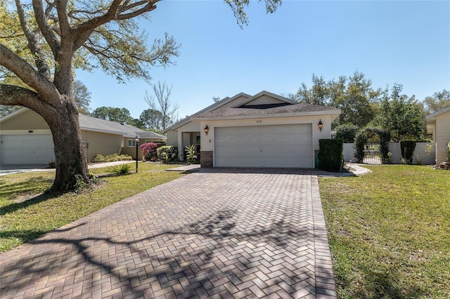 single story home featuring a garage, stucco siding, decorative driveway, and a front lawn