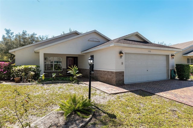 ranch-style home with brick siding, stucco siding, decorative driveway, and a garage