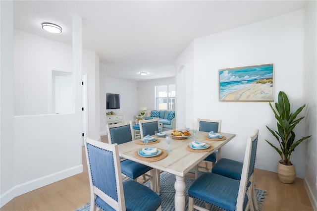 dining area featuring baseboards and light wood finished floors