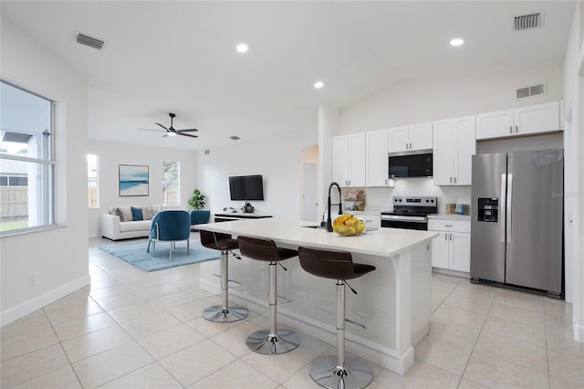 kitchen with visible vents, light countertops, arched walkways, light tile patterned flooring, and stainless steel appliances