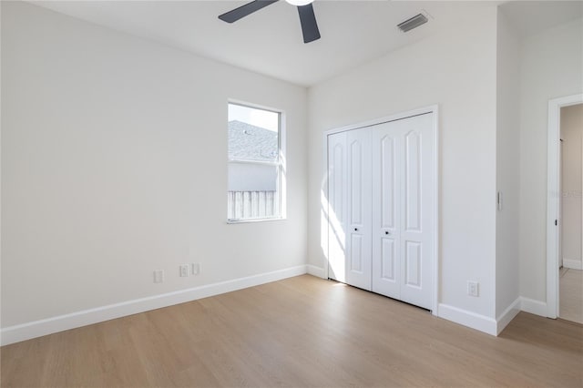 unfurnished bedroom with visible vents, wood finished floors, a closet, baseboards, and ceiling fan