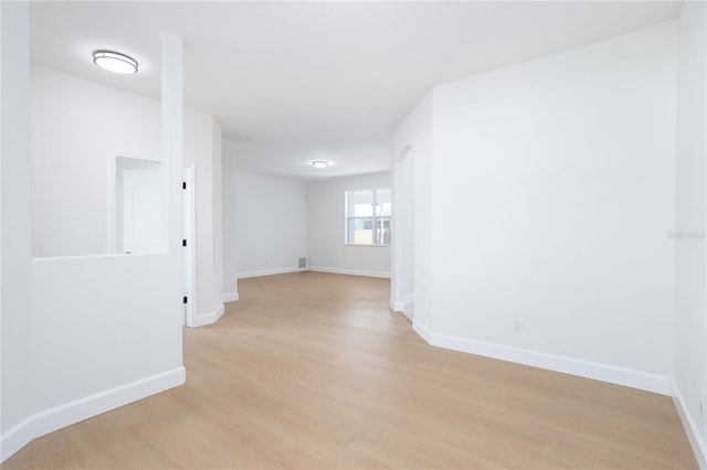 unfurnished room featuring baseboards and light wood-style floors