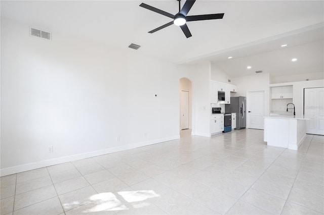 unfurnished living room featuring visible vents, arched walkways, lofted ceiling, and ceiling fan