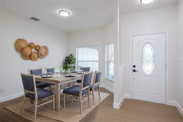 dining space with visible vents, light wood-style flooring, and baseboards