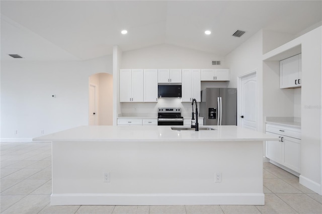 kitchen featuring visible vents, a large island, a sink, stainless steel appliances, and arched walkways