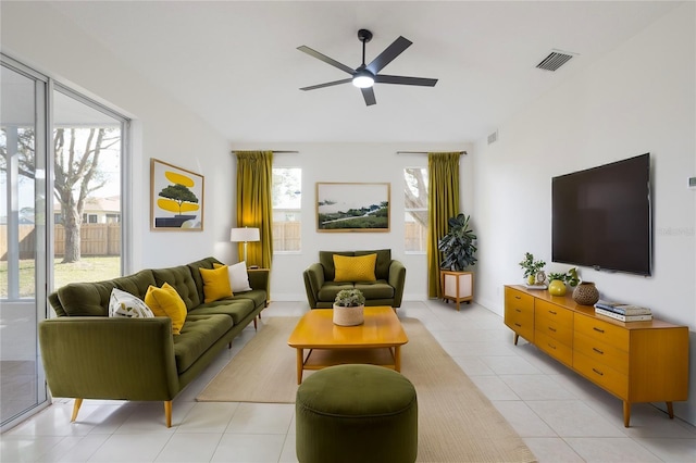 living area with visible vents, a healthy amount of sunlight, ceiling fan, and light tile patterned flooring