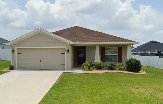 ranch-style house with a garage and a front yard