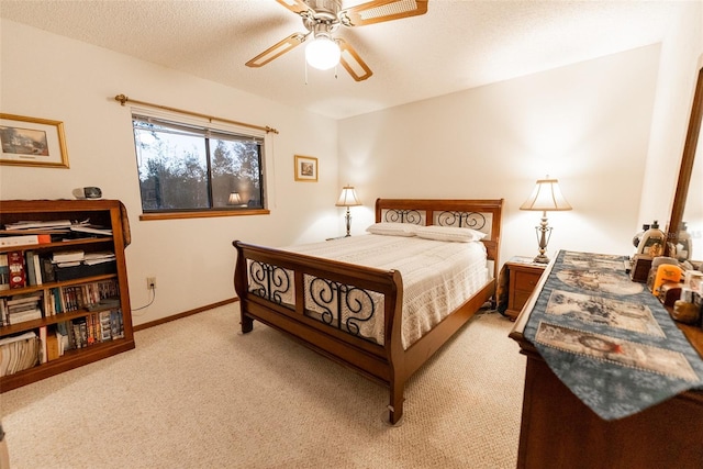 bedroom featuring ceiling fan, light colored carpet, and a textured ceiling