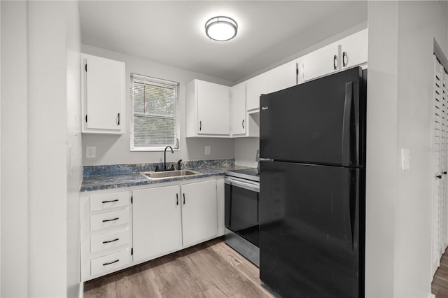 kitchen with sink, black fridge, white cabinetry, stainless steel electric range oven, and light hardwood / wood-style flooring