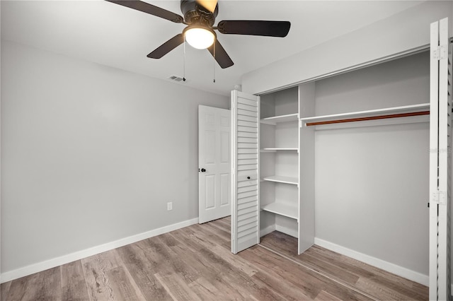 unfurnished bedroom with wood-type flooring, ceiling fan, and a closet