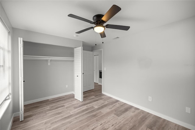 unfurnished bedroom featuring ceiling fan, light wood-type flooring, and a closet