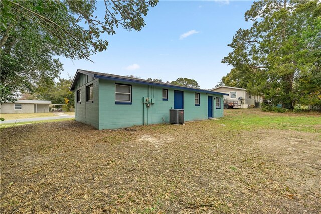 back of property with cooling unit and a lawn