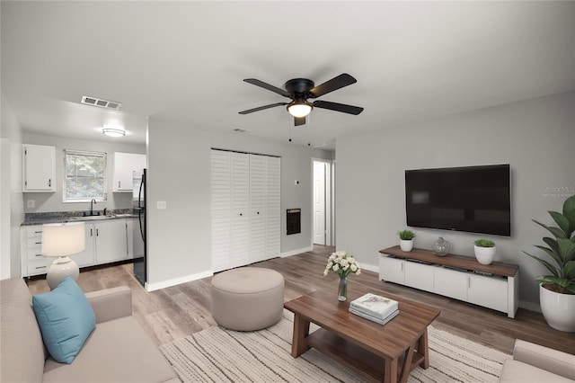 living room with ceiling fan, sink, and hardwood / wood-style floors