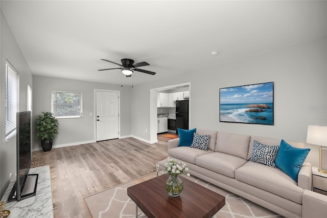 living room featuring light hardwood / wood-style flooring and ceiling fan