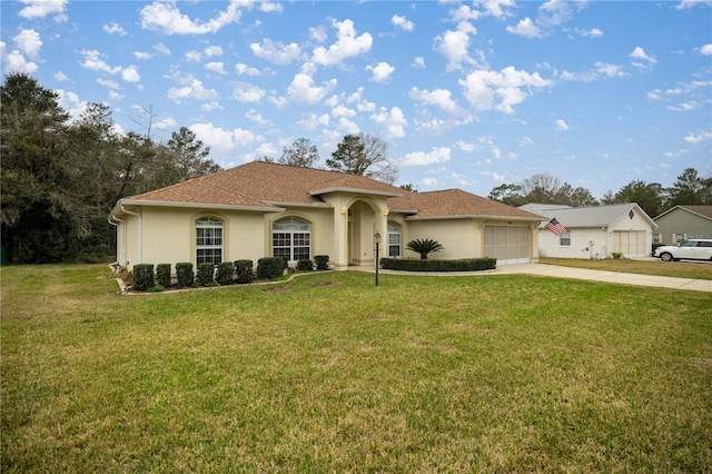 mediterranean / spanish-style home featuring stucco siding, a front lawn, an attached garage, and driveway