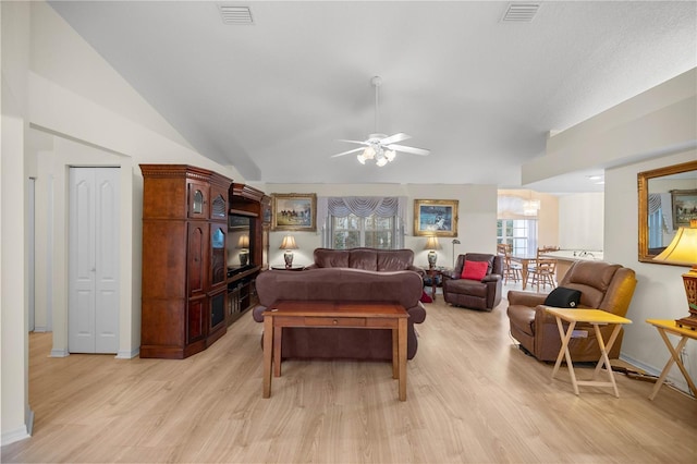 living area with lofted ceiling, a ceiling fan, visible vents, and light wood-type flooring