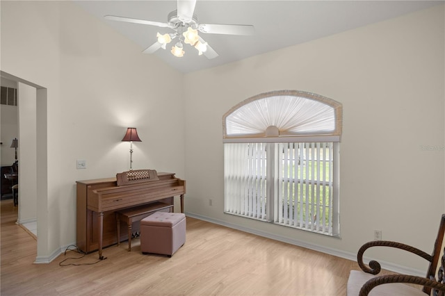 living area with ceiling fan, baseboards, lofted ceiling, and wood finished floors