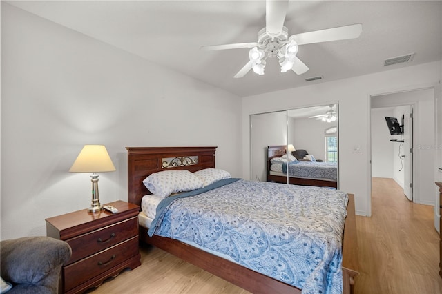 bedroom featuring visible vents, light wood-style floors, a closet, and a ceiling fan