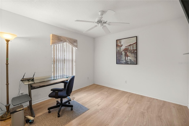 office featuring a ceiling fan, light wood-style floors, and baseboards