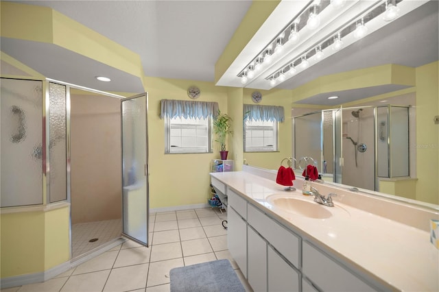 bathroom with tile patterned floors, a shower stall, vanity, and baseboards