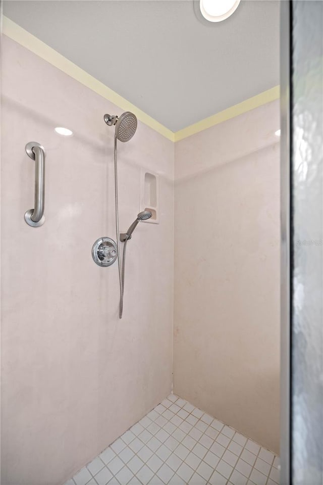 bathroom with tiled shower and tile patterned flooring