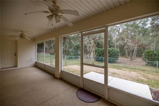 unfurnished sunroom featuring ceiling fan