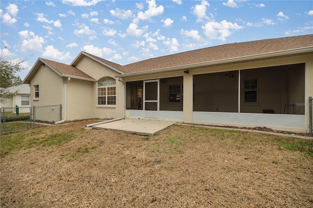 back of property with a gate, fence, a yard, and a sunroom