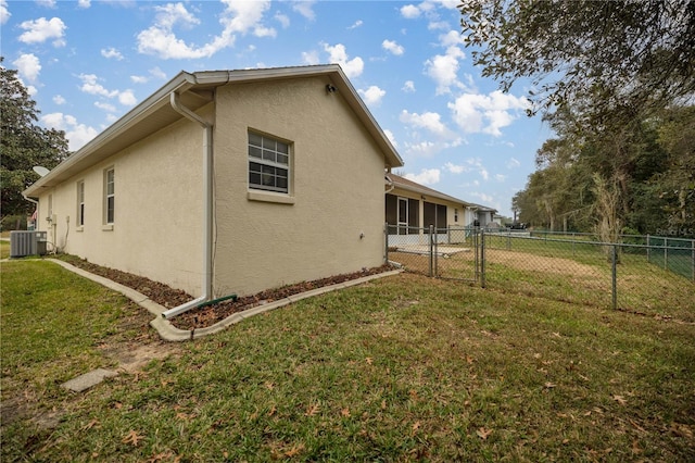 view of property exterior with a yard, fence, central AC, and stucco siding