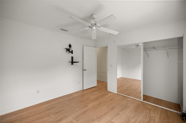 unfurnished bedroom featuring light wood-style floors, a closet, a ceiling fan, visible vents, and baseboards