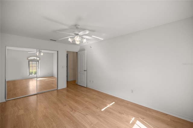 unfurnished bedroom featuring light wood finished floors, a closet, visible vents, and ceiling fan