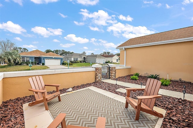 view of patio / terrace featuring a gate, fence, and a residential view