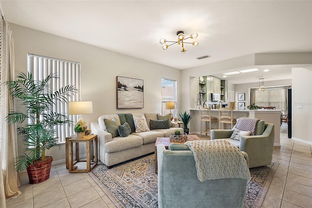 tiled living room with an inviting chandelier