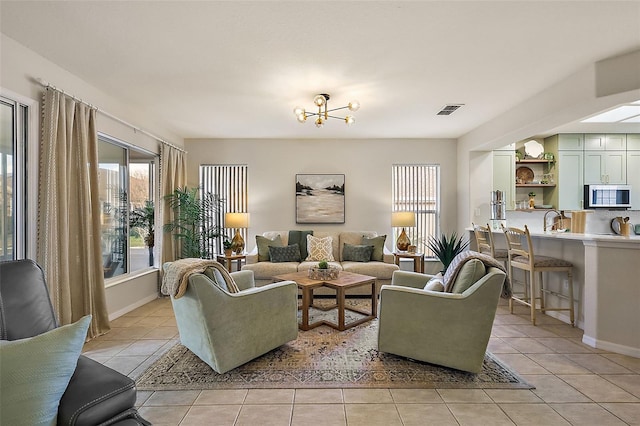 living room featuring light tile patterned floors, visible vents, and baseboards