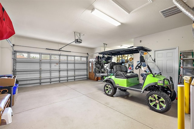 garage featuring a garage door opener and visible vents