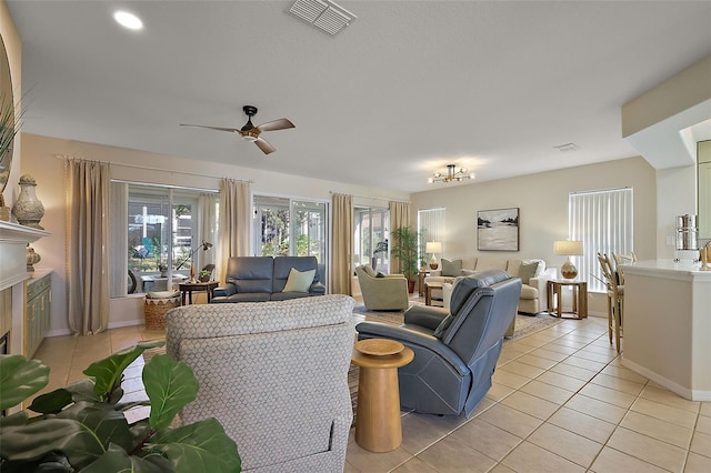 living room with visible vents, baseboards, a fireplace, light tile patterned flooring, and a ceiling fan