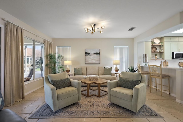 living area with light tile patterned floors, visible vents, and baseboards