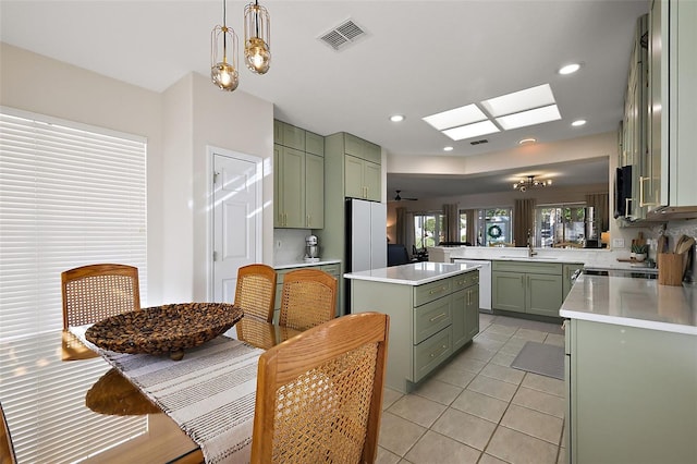 kitchen with light countertops, a skylight, visible vents, and green cabinetry